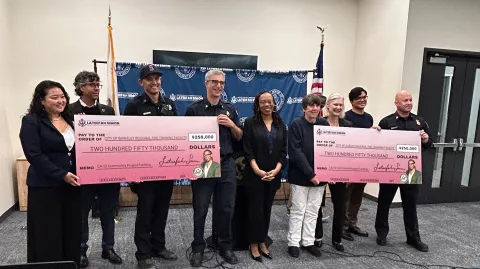 Congresswoman Simon, Mayors, Fire Chiefs, and Guests Holding Two Large Checks for Fire Funding